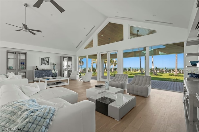 living room featuring french doors, light hardwood / wood-style floors, ceiling fan, and high vaulted ceiling