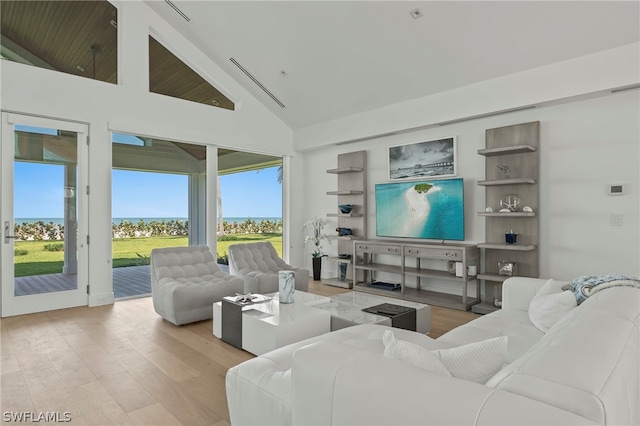 living room with high vaulted ceiling and light hardwood / wood-style floors