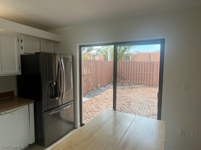 kitchen featuring white cabinets, dishwasher, and stainless steel refrigerator with ice dispenser