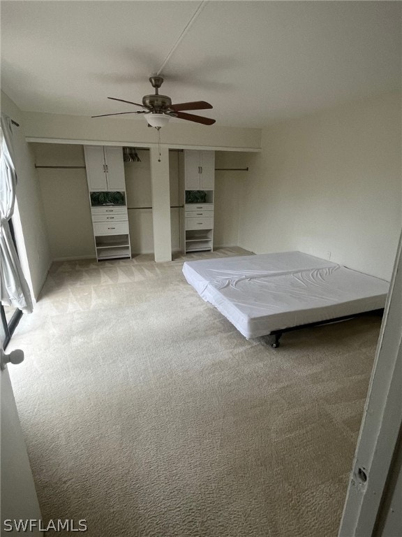 unfurnished bedroom featuring light colored carpet and ceiling fan