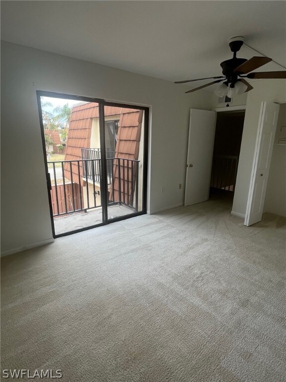 carpeted spare room with ceiling fan