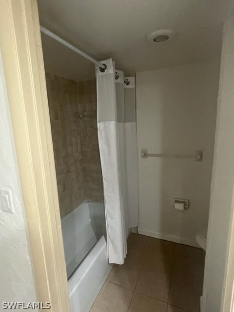 bathroom featuring tile floors, toilet, and shower / bath combo with shower curtain