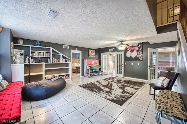 living room with french doors, ceiling fan, tile patterned floors, and a textured ceiling