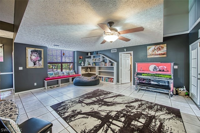 playroom with a textured ceiling, tile patterned floors, and ceiling fan