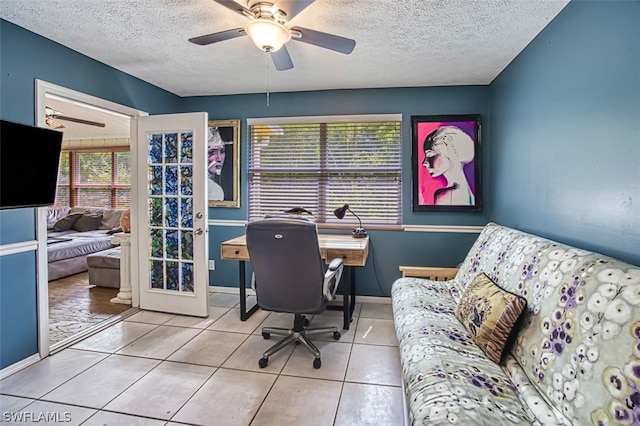 tiled office space featuring a textured ceiling and ceiling fan