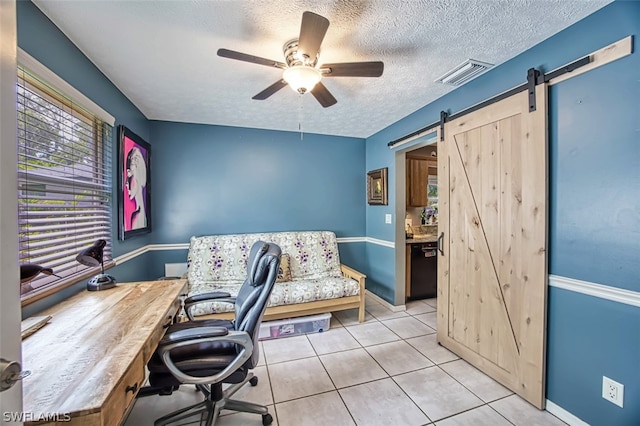 office with ceiling fan, light tile patterned floors, a barn door, and a textured ceiling