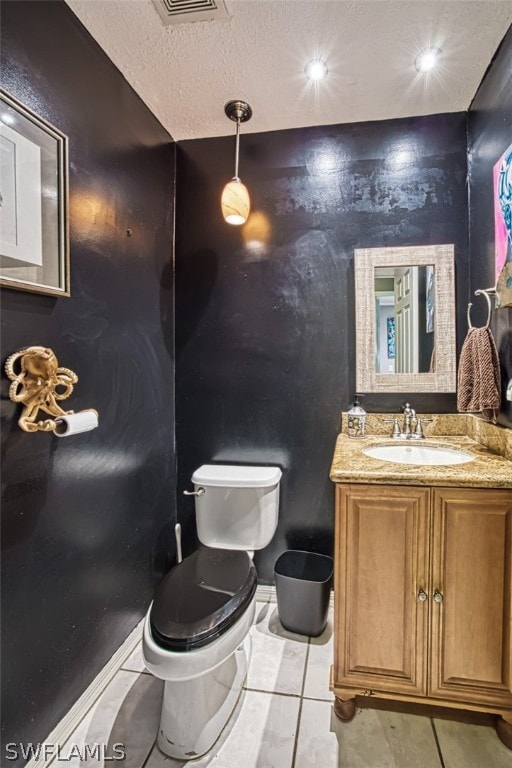 bathroom with vanity, tile patterned floors, a textured ceiling, and toilet