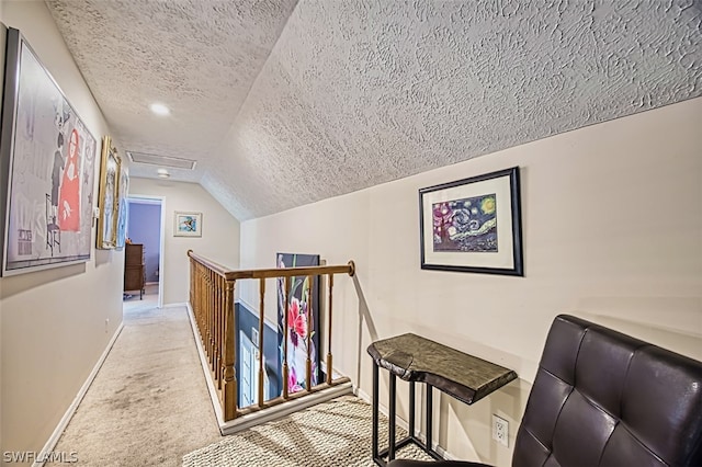 corridor with lofted ceiling, light colored carpet, and a textured ceiling