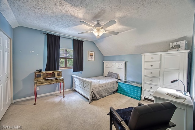 bedroom with lofted ceiling, a textured ceiling, ceiling fan, and a closet