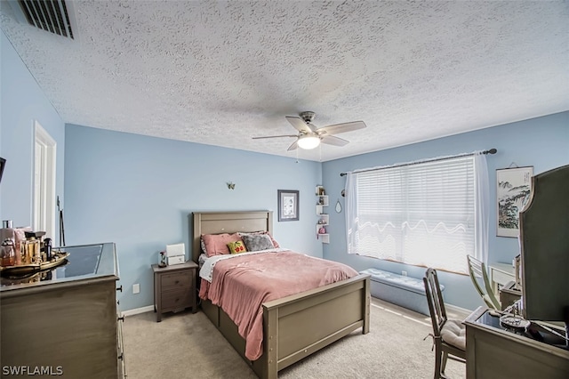 carpeted bedroom featuring a textured ceiling and ceiling fan