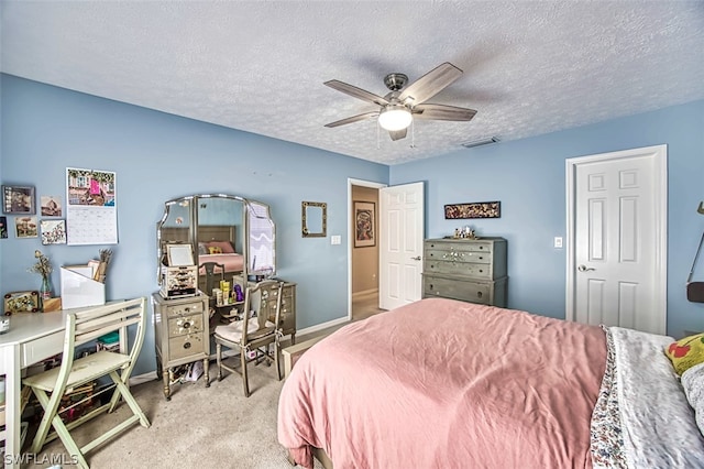 carpeted bedroom featuring ceiling fan and a textured ceiling