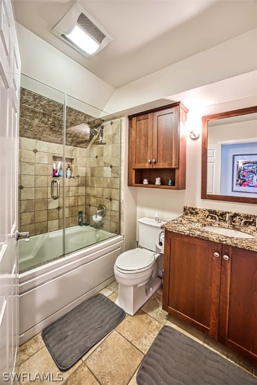 full bathroom with vanity, lofted ceiling, toilet, and combined bath / shower with glass door