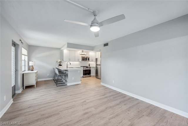 unfurnished office featuring sink, light hardwood / wood-style flooring, and ceiling fan