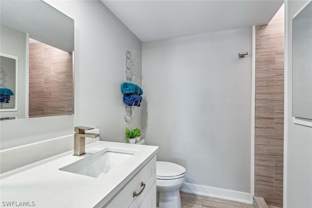 bathroom with hardwood / wood-style flooring, toilet, and large vanity