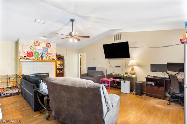 living room featuring lofted ceiling, light hardwood / wood-style flooring, ceiling fan, and a fireplace