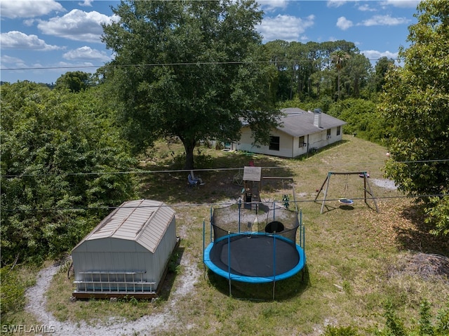 view of yard with a trampoline and a shed