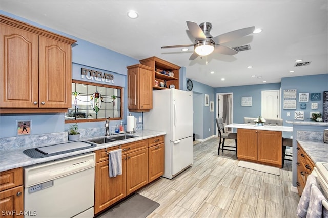 kitchen with a kitchen breakfast bar, ceiling fan, sink, and white appliances