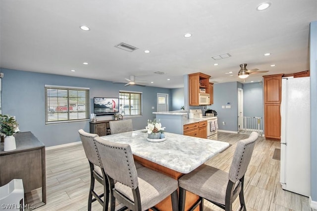 dining space featuring ceiling fan and light hardwood / wood-style floors