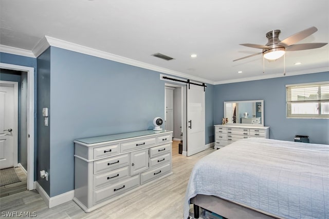 bedroom with ceiling fan, ornamental molding, a barn door, and light hardwood / wood-style floors