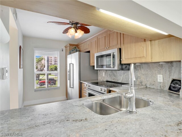 kitchen featuring ceiling fan, sink, stainless steel appliances, light brown cabinetry, and decorative backsplash