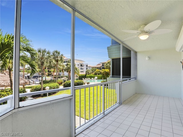 unfurnished sunroom with ceiling fan