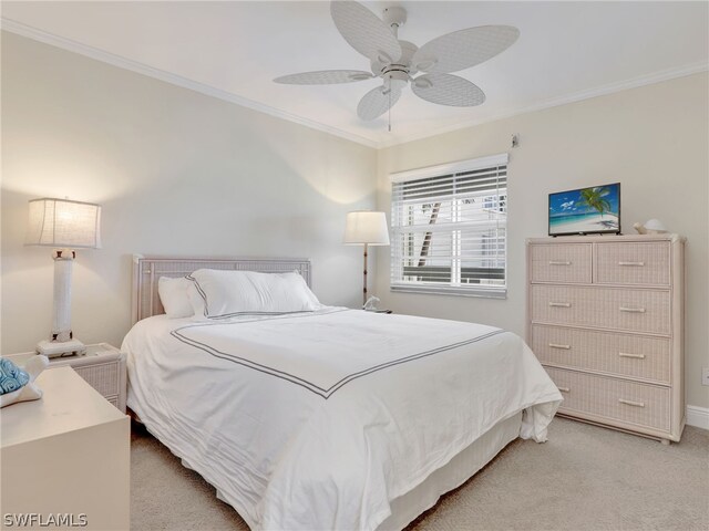 bedroom featuring ceiling fan, light colored carpet, and crown molding