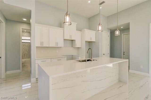 kitchen featuring hanging light fixtures, sink, a spacious island, and white cabinetry