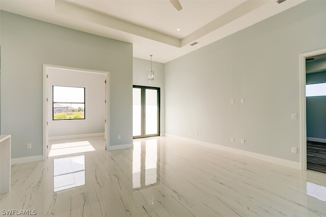 spare room featuring light wood-type flooring and a tray ceiling