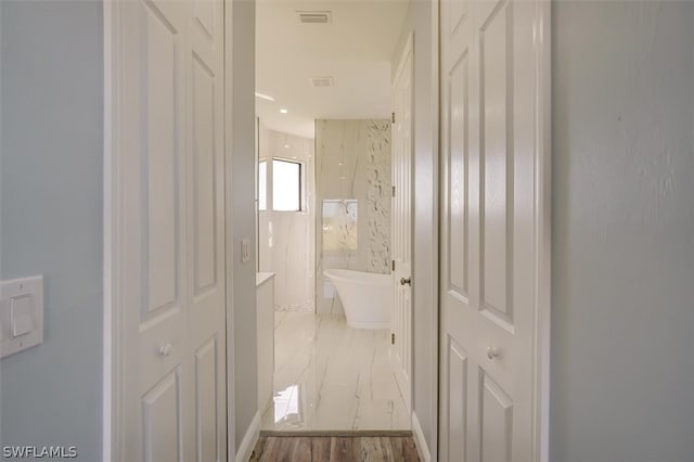 hall with tile flooring and tile walls