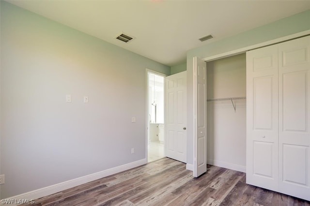 unfurnished bedroom featuring hardwood / wood-style floors and a closet