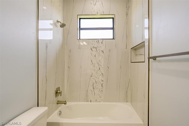 bathroom featuring tiled shower / bath and toilet