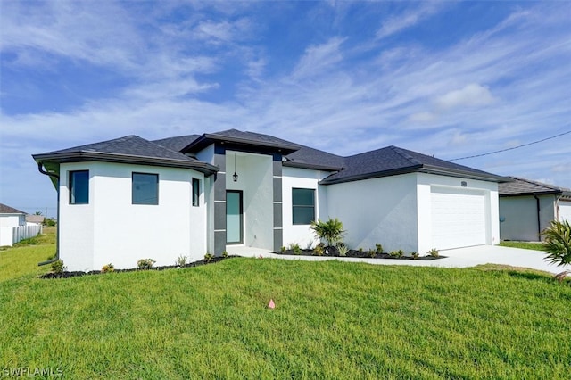 prairie-style home featuring a garage and a front lawn