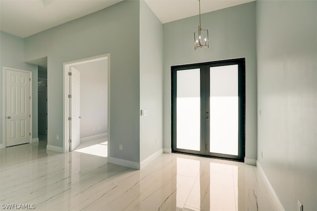 interior space featuring french doors, light tile flooring, and a chandelier