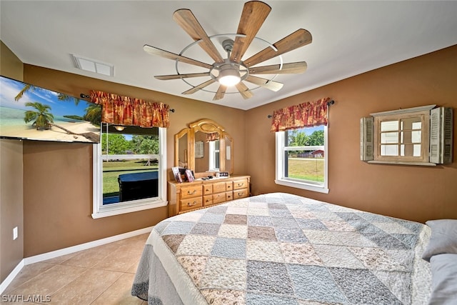 tiled bedroom featuring ceiling fan