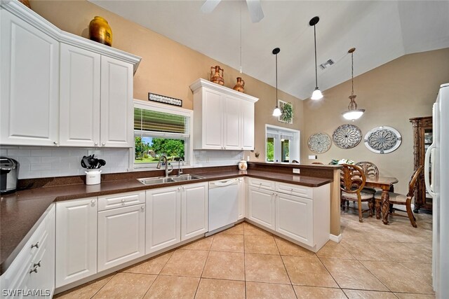 kitchen featuring white cabinets, kitchen peninsula, sink, vaulted ceiling, and tasteful backsplash