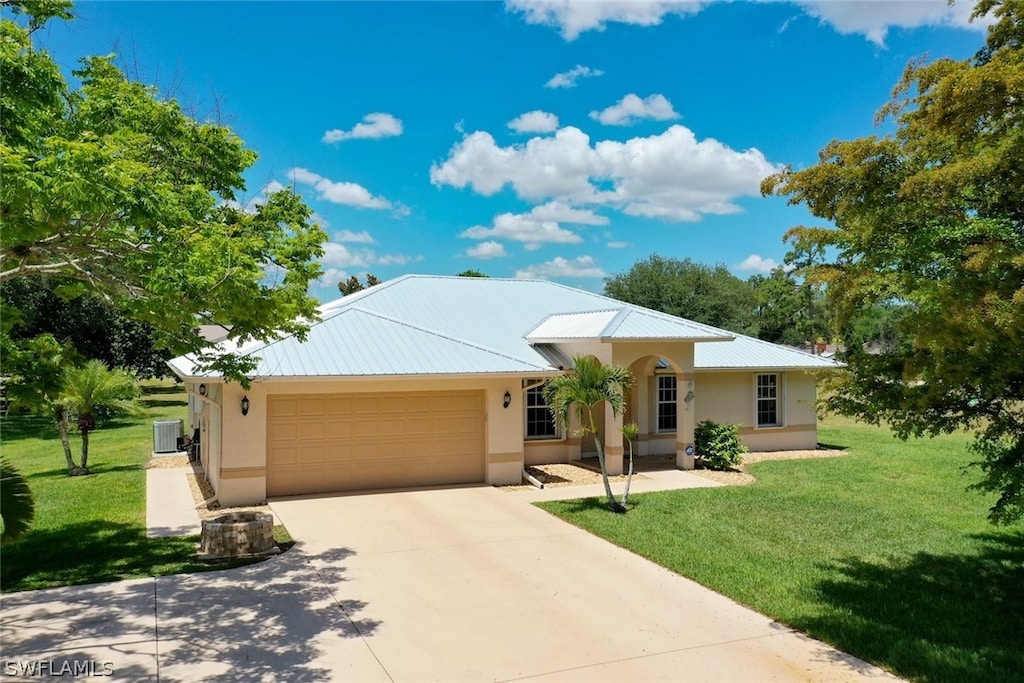 view of front of house featuring a front yard, a garage, and central AC unit