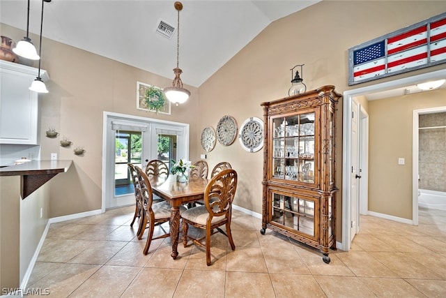 dining area with french doors, vaulted ceiling, and light tile floors