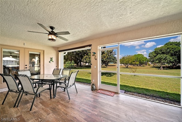 unfurnished sunroom with ceiling fan