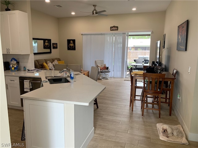 kitchen with white cabinets, sink, ceiling fan, and a kitchen bar