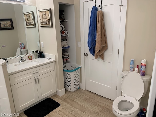 bathroom featuring oversized vanity, toilet, and hardwood / wood-style flooring