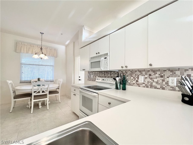 kitchen featuring white cabinets, white appliances, tasteful backsplash, hanging light fixtures, and an inviting chandelier