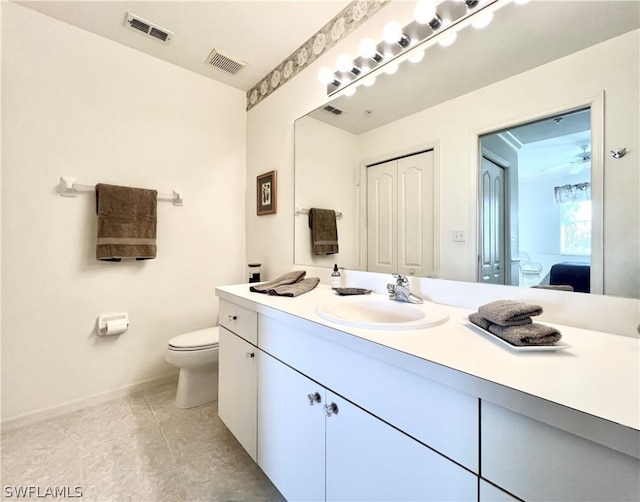 bathroom featuring toilet, oversized vanity, and tile flooring