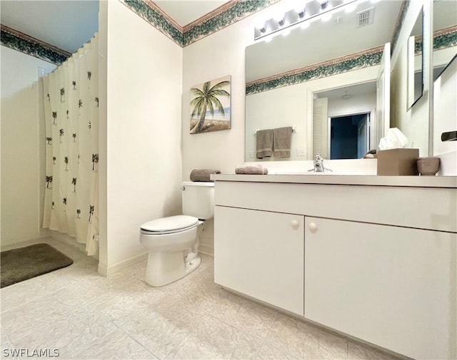 bathroom with tile flooring, vanity with extensive cabinet space, and toilet