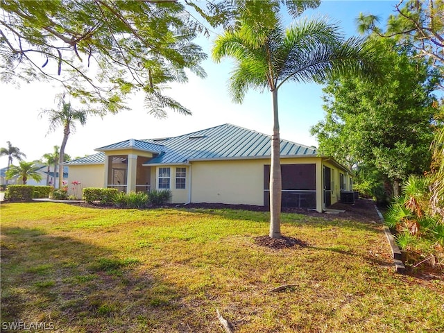 back of property with central air condition unit and a lawn