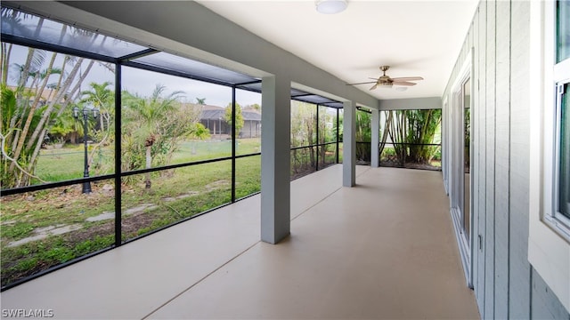 unfurnished sunroom with ceiling fan