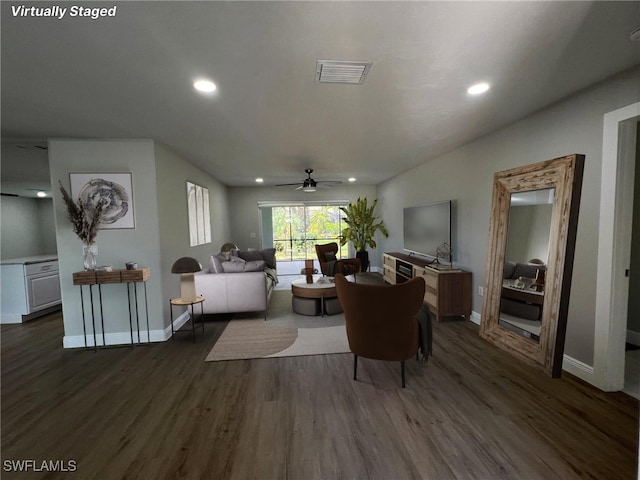 living room featuring ceiling fan and dark wood-type flooring