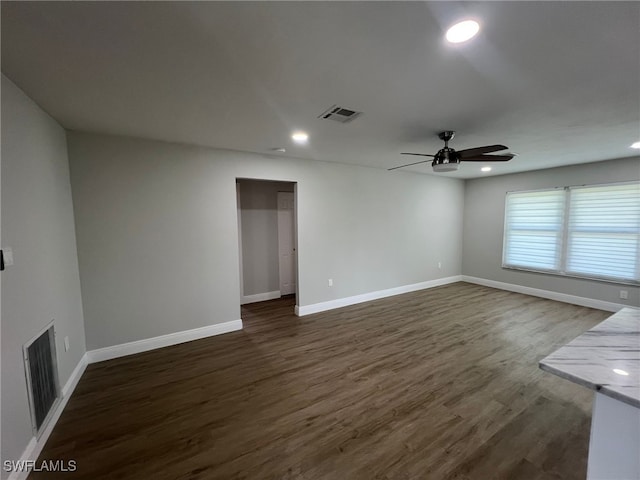 empty room with ceiling fan and dark wood-type flooring