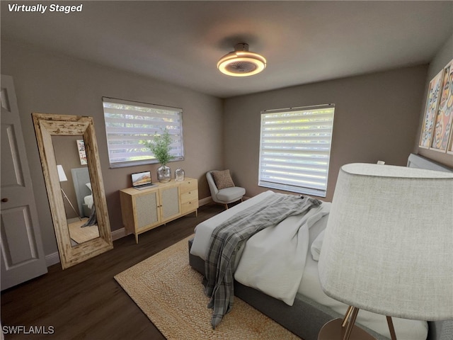 bedroom with multiple windows and dark wood-type flooring