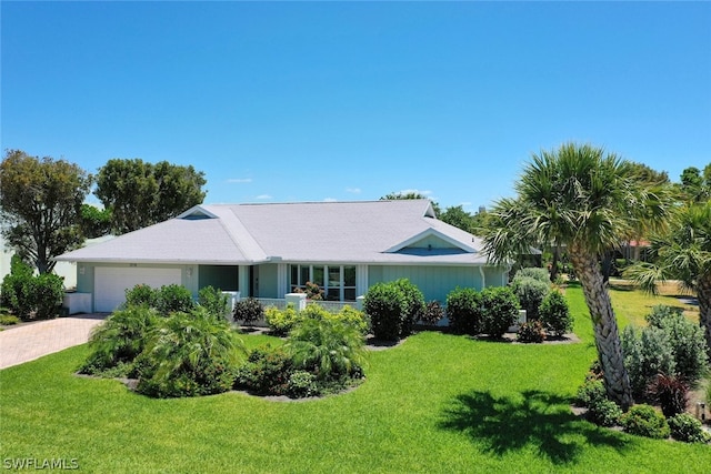 ranch-style home featuring a garage and a front lawn