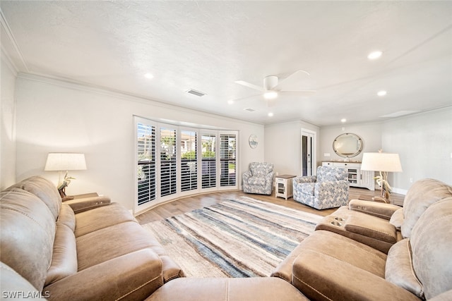 living room featuring hardwood / wood-style floors, ceiling fan, and crown molding